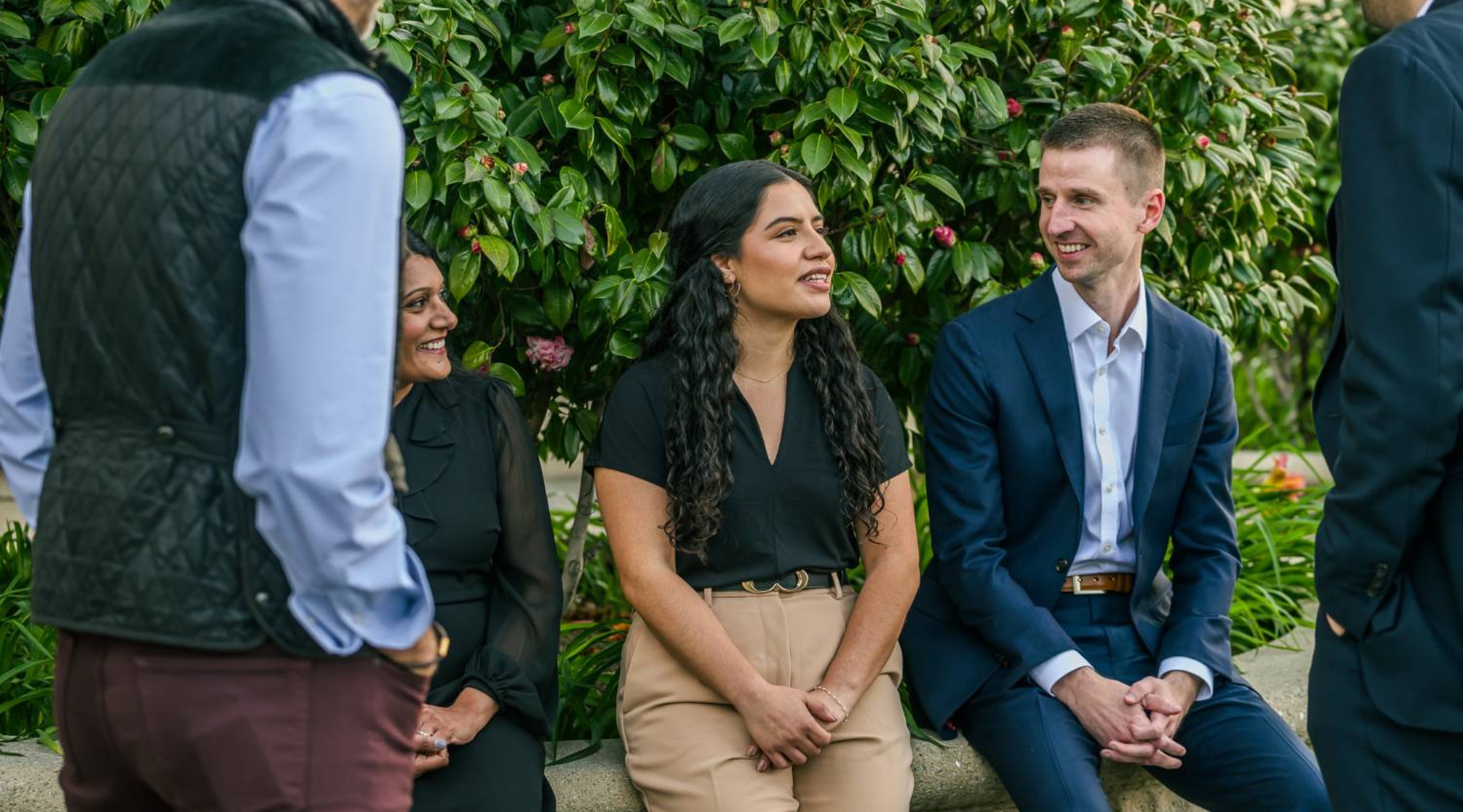Three HGGC team members sitting outside on a bench