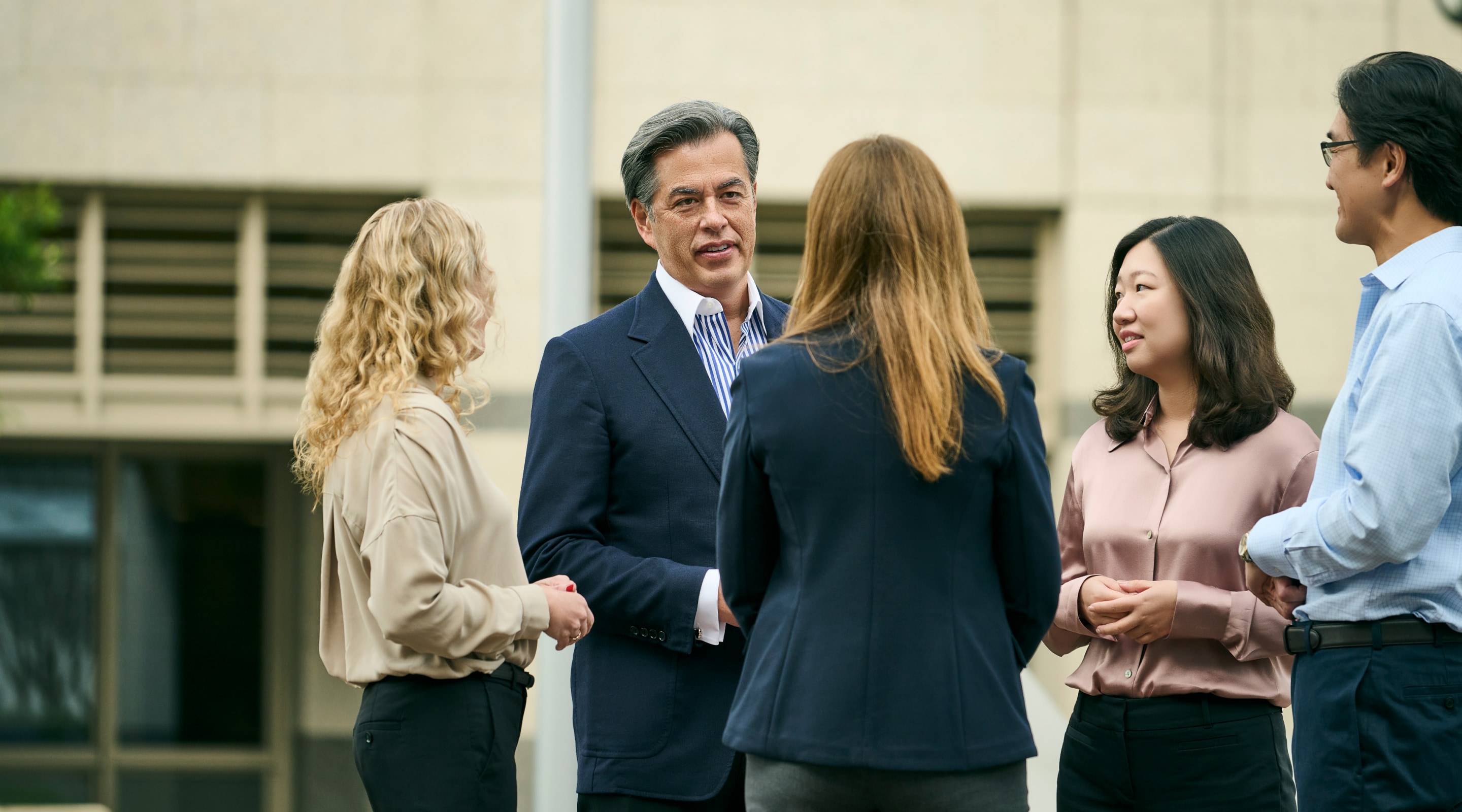 Group of HGGC team standing outside in a group talking